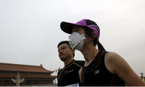 Runner phải đeo khẩu trang vì ô nhiễm không khí ở Bắc Kinh. Ảnh: Reuters