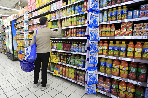 Một người mua đang chọn đồ uống trong siêu thị ở Thượng Hải. Ảnh: Reuters