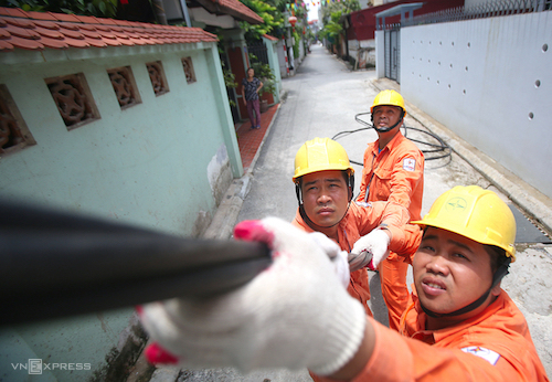 Công nhân Điện lực Hà Nội sửa chữa đường dây tại quận Long Biên. Ảnh: Ngọc Thành