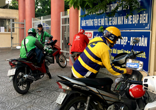 Tài xế Grab, be, Go-Viet đỗ xe ở một cổng trường tại quận Bình Thạnh, TP HCM. Ảnh: Viễn Thông