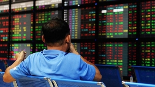 Nhà đầu tư theo dõi bảng điện tử tại một công ty chứng khoán Hà Nội. Ảnh: AFP.