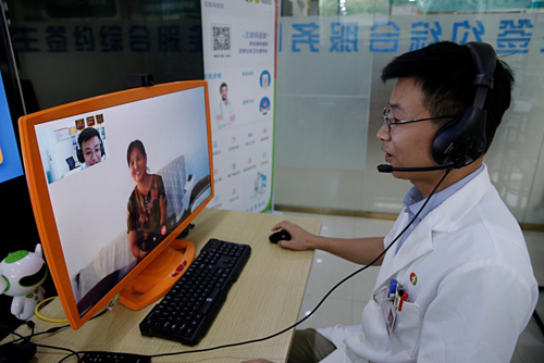 Bác sĩ của Trung tâm Y tế Zhuojing (Sơn Đông) trò chuyện cùng người già. Ảnh: Reuters