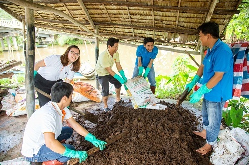 Tình nguyện viên cùng người dân địa phương thu gom rơm rạ ủ phân hữu cơ.