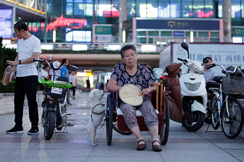 Một phụ nữ 68 tuổi đang ngồi hóng mát ở quảng trường tại Duy Phường, Sơn Đông. Ảnh: Reuters