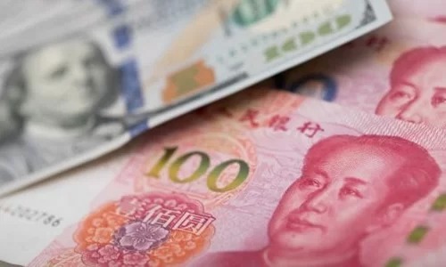 Đồng 100 USD của Mỹ và 100 NDT của Trung Quốc. Ảnh: AFP