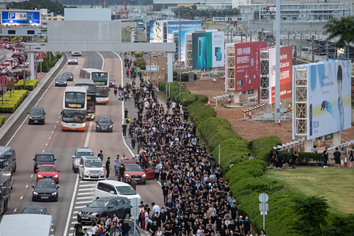 Người biểu tình và hành khách rời Sân bay Quốc tế Hong Kong chiều qua. Ảnh: Bloomberg