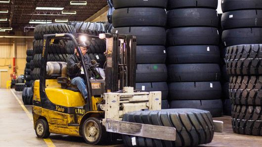 An employee uses a forklift to move large construction tires at the Titan Tire Corp. warehouse in Bryan, Ohio.